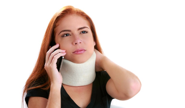 jeune femme rousse téléphonant et portant collier cervicale, minerve à cause névralgie d'arnold