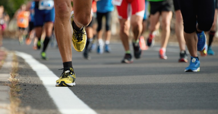 photo d'un groupe de coureur dans un marathon qui met en évidence l'impact du pied au sol et l'augmentation du risque d'apparition d'un syndrome rotulien chez le coureur